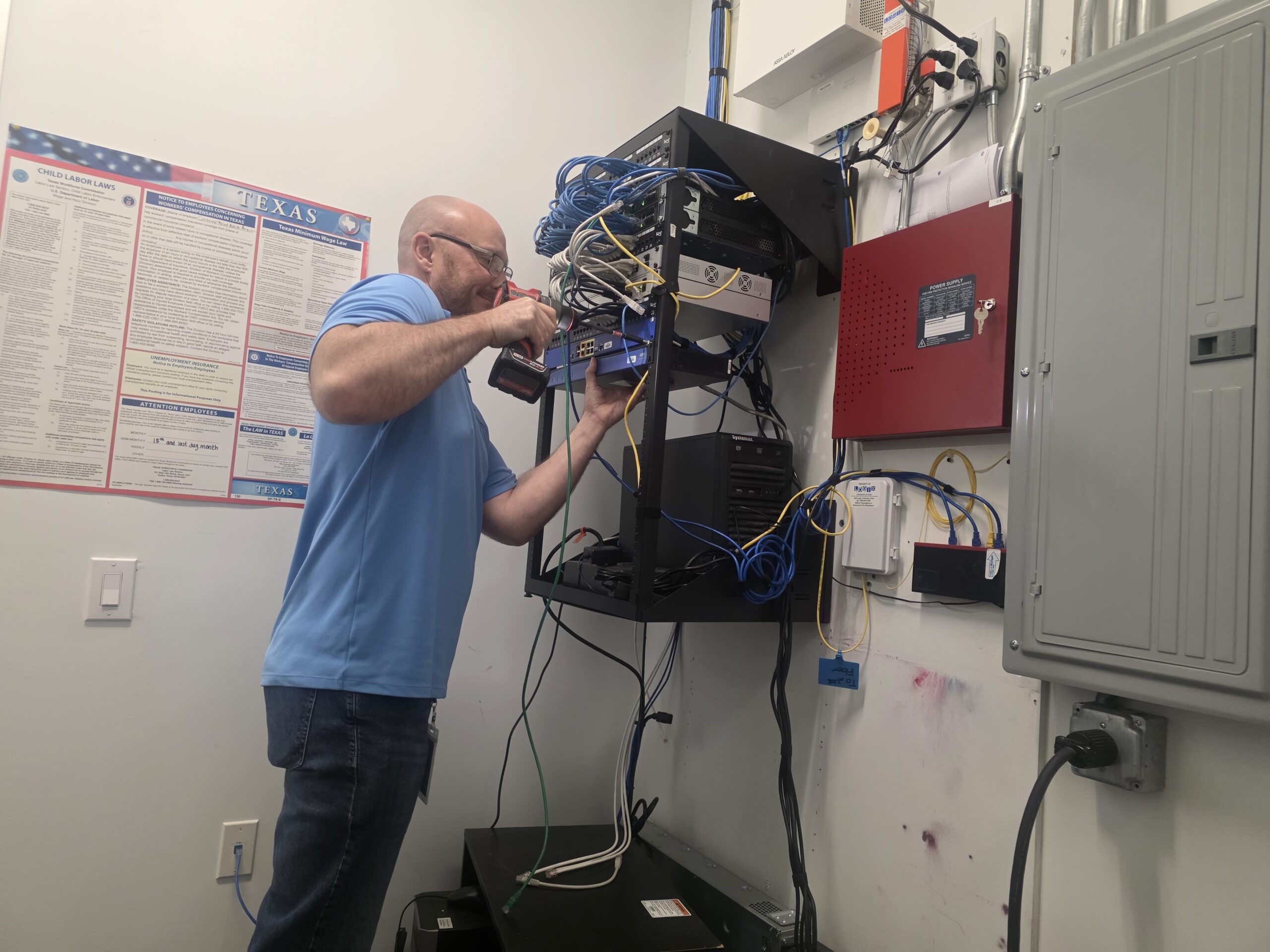Technician working on wall-mounted network equipment